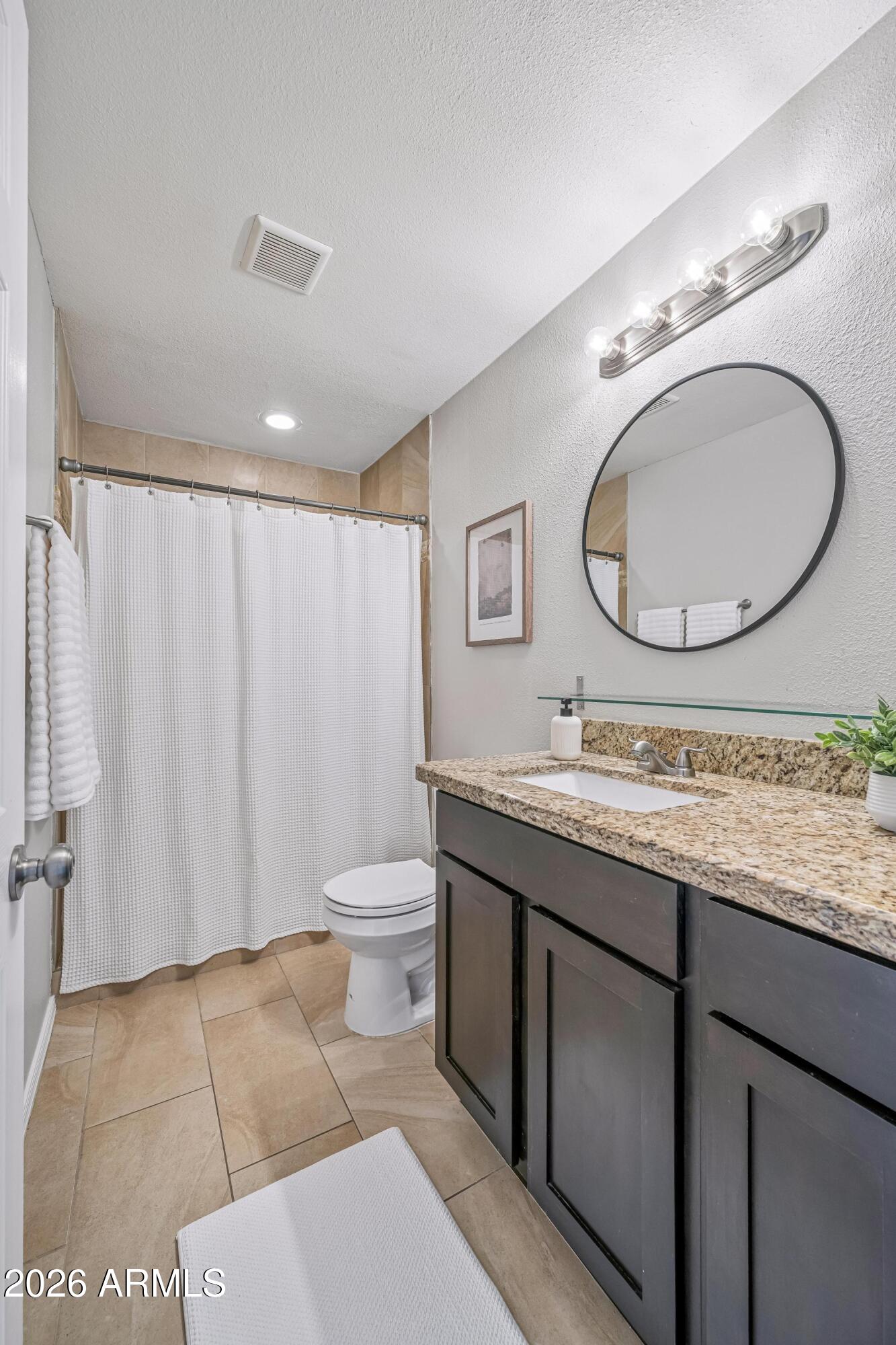 2327 East Weldon Avenue Phoenix, AZ 85016 - Photo 21 of 34 a bathroom with a granite countertop sink and a mirror
