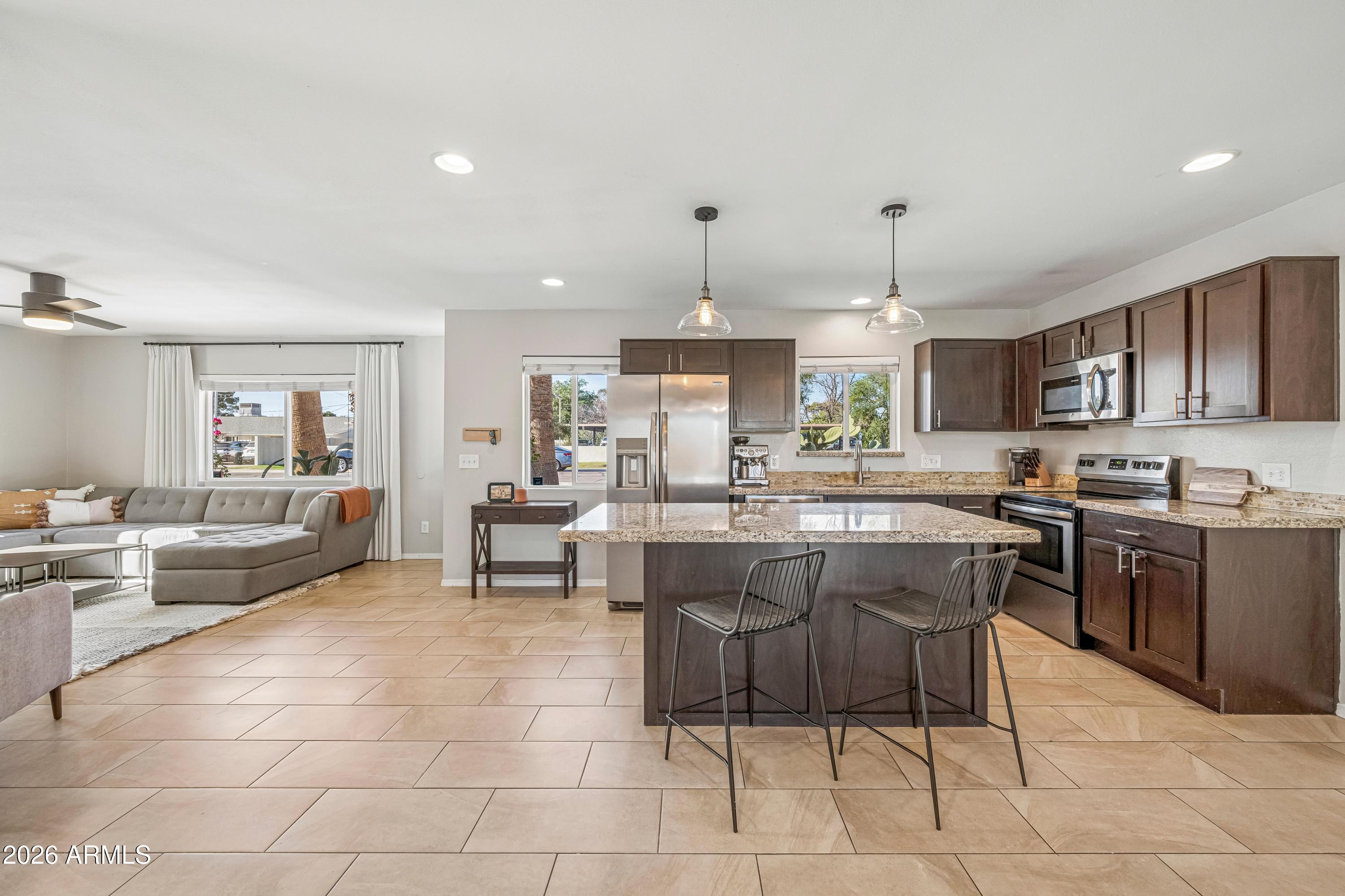 2327 East Weldon Avenue Phoenix, AZ 85016 - Photo 5 of 34 a large kitchen with a large counter top space a sink stainless steel appliances and cabinets