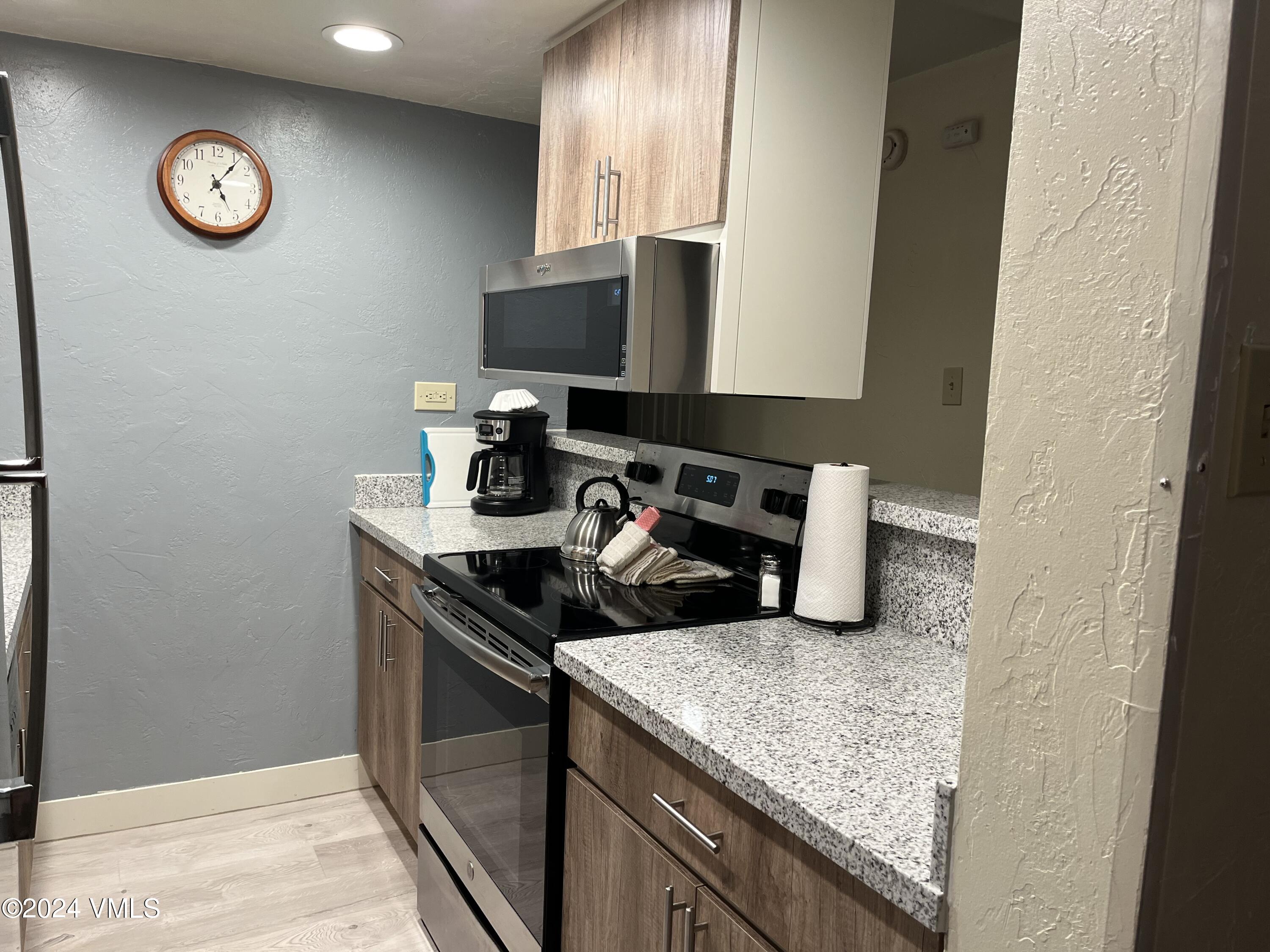 1020 Vail View Drive, Unit 120846 Vail, CO 81657 - Photo 20 of 20 a kitchen with a sink and a stove with wooden floor