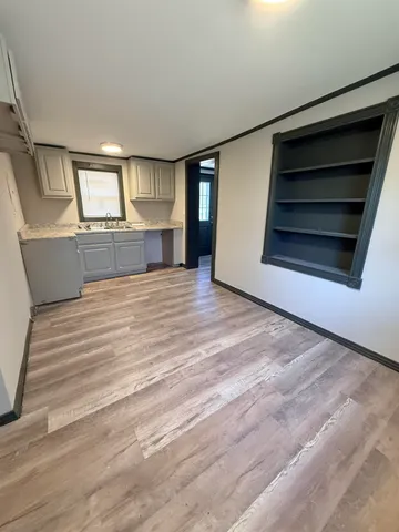 a view of an empty room with a fireplace and cabinet