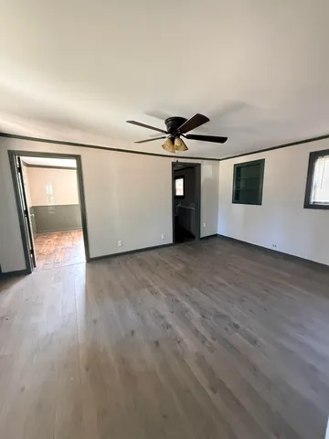 a view of a big room with wooden floor and windows