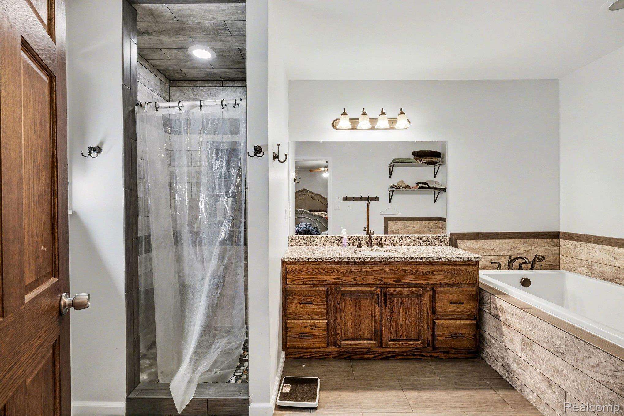 2800 Meadowdale Road Metamora, MI 48455 - Photo 14 of 28 Ensuite bathroom with a garden tub, vanity, a stall shower, and light tile patterned floors
