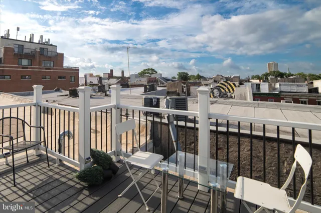 a view of a balcony with wooden chairs