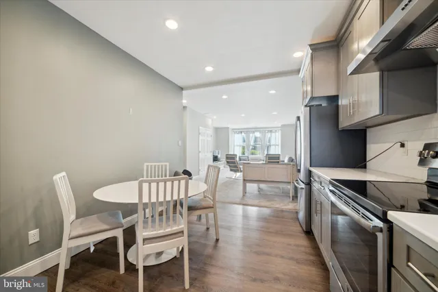a kitchen with stainless steel appliances a stove a table and chairs