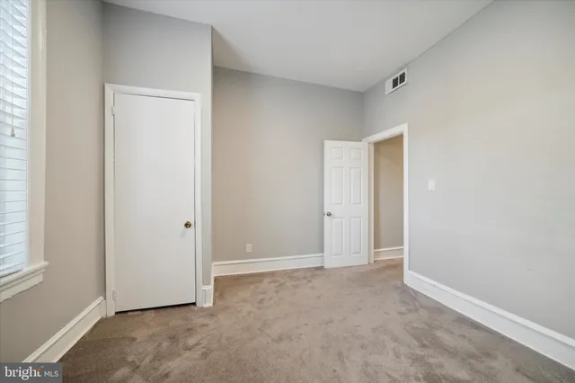 a view of a hallway with wooden floor and closet area