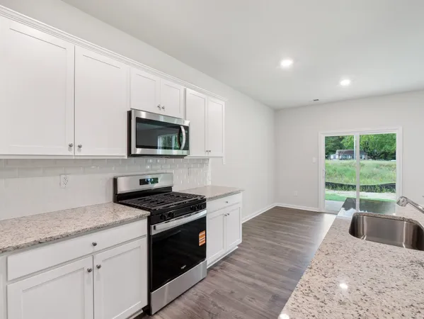 a kitchen with granite countertop a stove a sink and a granite counter tops