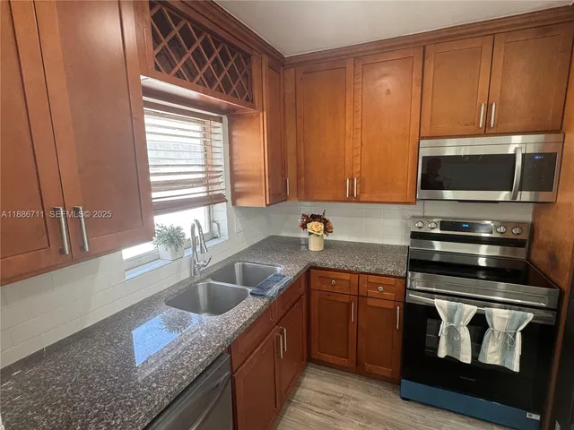 a kitchen with stainless steel appliances granite countertop a sink stove and microwave