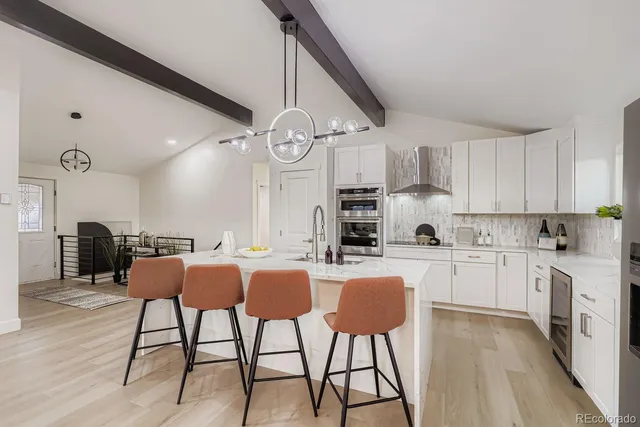 a large kitchen with a table and stainless steel appliances