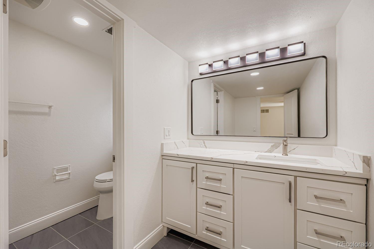 3435 West Dawson Road Sedalia, CO 80135 - Photo 27 of 42 a bathroom with a double vanity sink and a mirror