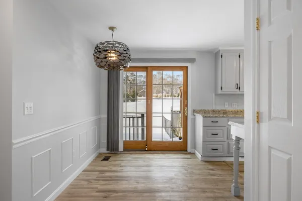a view of a room with wooden floor chandelier and windows