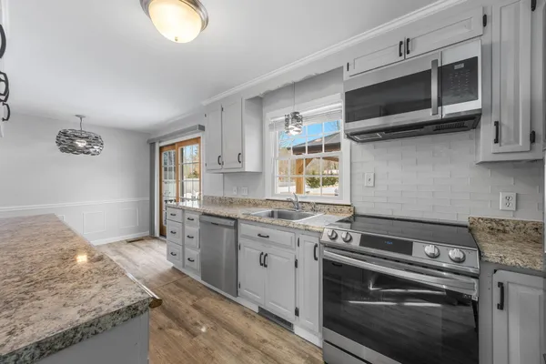 a kitchen with stainless steel appliances granite countertop a stove and a microwave