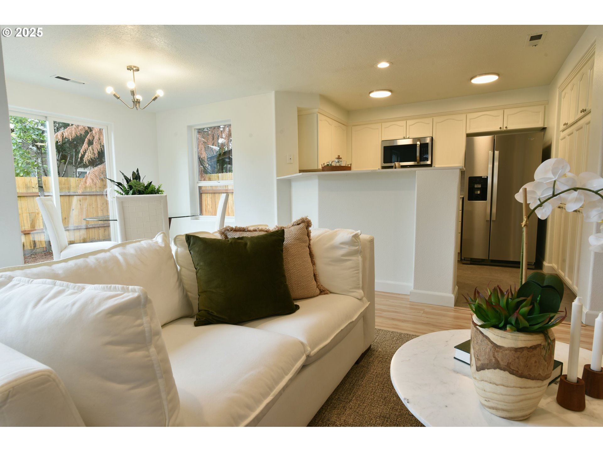 20382 Southwest Monson Street Beaverton, OR 97003 - Photo 11 of 28 a living room with furniture kitchen and a chandelier