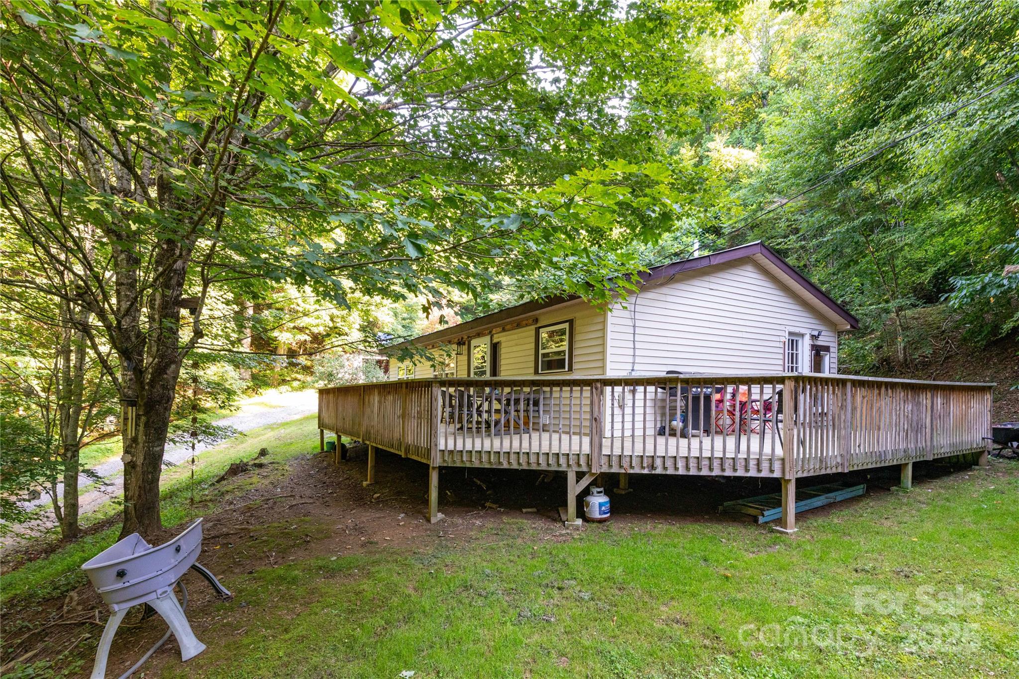 a view of a house with a yard and deck