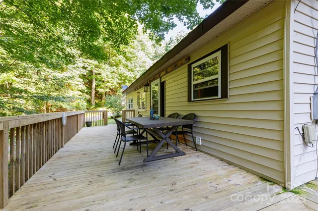 a view of a patio with table and chairs with wooden floor and fence