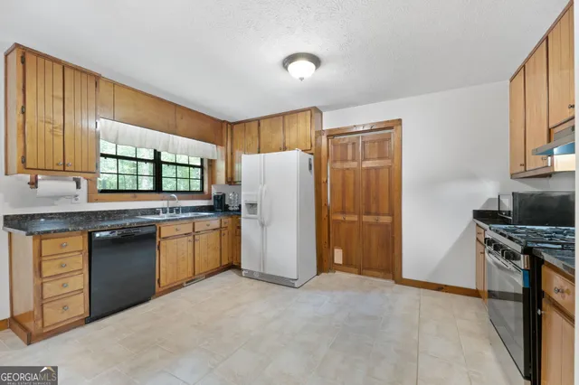 a kitchen with stainless steel appliances granite countertop a refrigerator and a sink