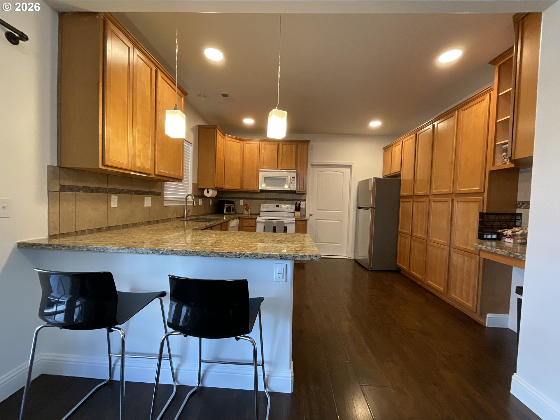 1310 Gales Creek Road Forest Grove, OR 97116 - Photo 14 of 39 a kitchen with stainless steel appliances granite countertop a refrigerator a stove a sink cabinets and a wooden floor