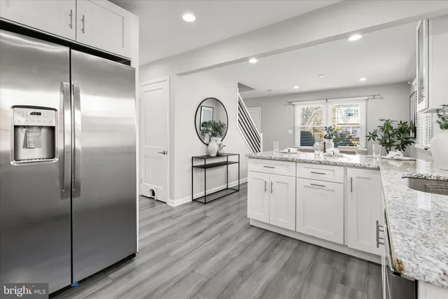 a kitchen with white cabinets and sink