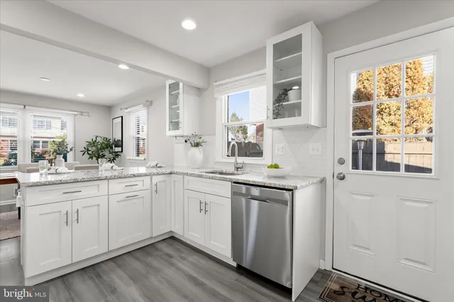 a kitchen with granite countertop white cabinets and white appliances