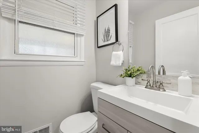 a bathroom with a toilet a sink and mirror