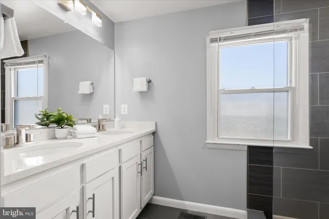 a bathroom with a sink a vanity and a window