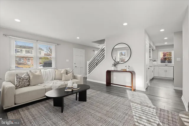 a living room with furniture a rug and white walls