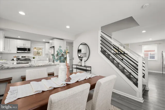 a living room with furniture a flat screen tv and kitchen view