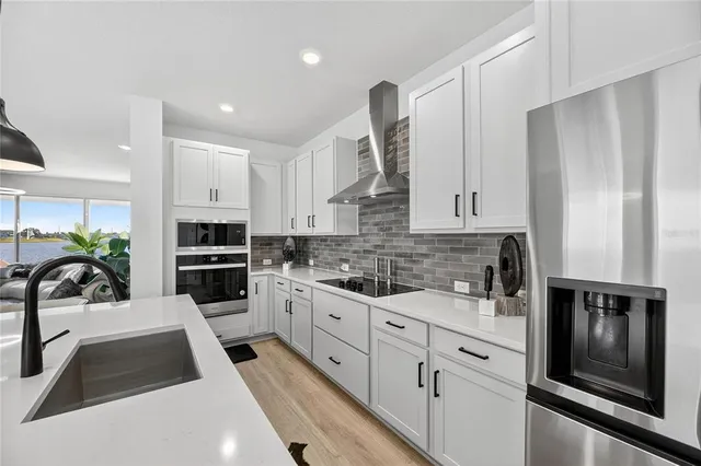 a kitchen with stainless steel appliances kitchen island granite countertop a sink and a stove