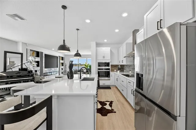a kitchen with kitchen island a sink stove and wooden floor