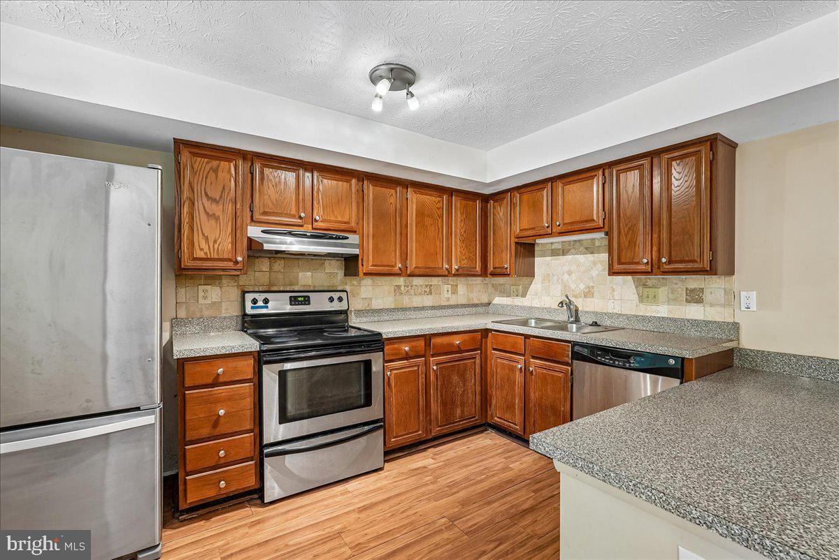 2331 Middle Creek Lane Reston, VA 20191 - Photo 21 of 78 a kitchen with stainless steel appliances granite countertop wooden cabinets granite counter tops and a window