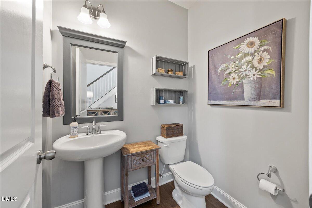 216 Mayfield Drive Apex, NC 27539 - Photo 11 of 66 a bathroom with a toilet a sink and mirror
