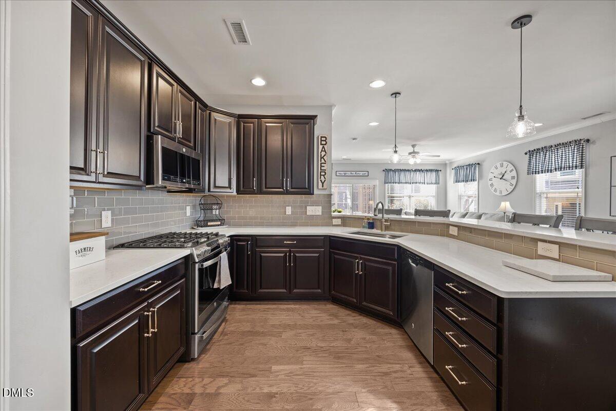 216 Mayfield Drive Apex, NC 27539 - Photo 12 of 66 a kitchen with stainless steel appliances granite countertop a sink stove and refrigerator
