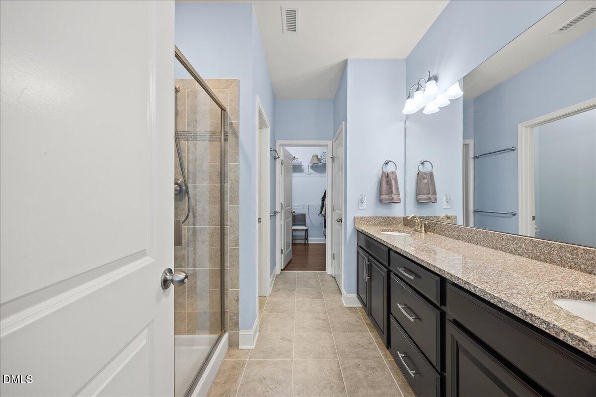 216 Mayfield Drive Apex, NC 27539 - Photo 24 of 66 a spacious bathroom with a granite countertop sink a mirror and a shower