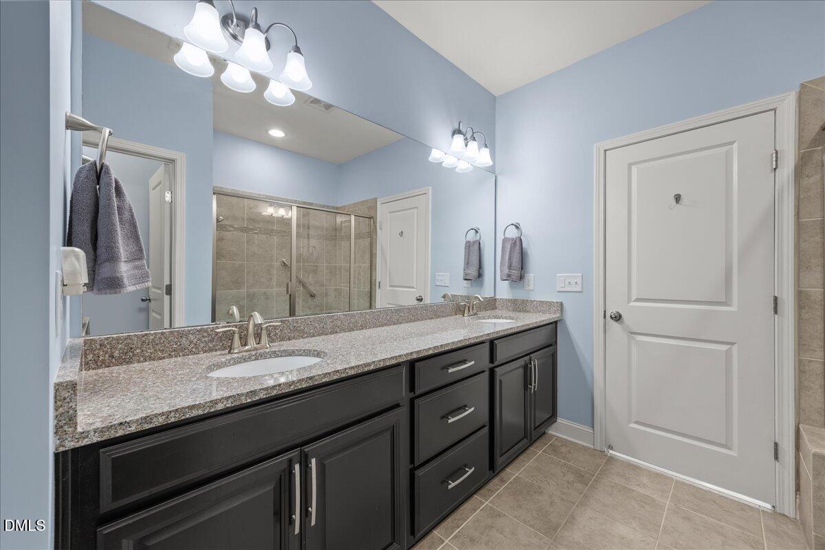 216 Mayfield Drive Apex, NC 27539 - Photo 27 of 66 a bathroom with a granite countertop sink a large mirror and a light fixture