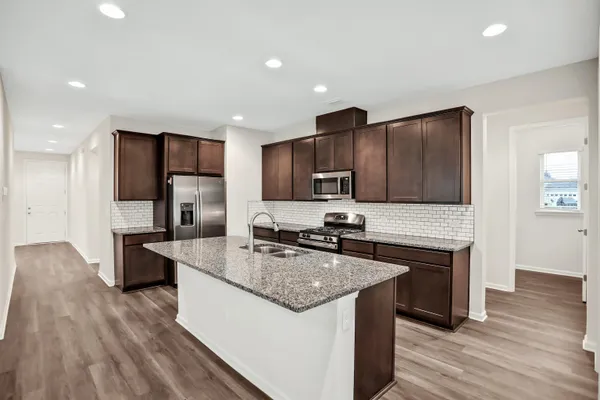 a kitchen with stainless steel appliances granite countertop a sink stove and refrigerator