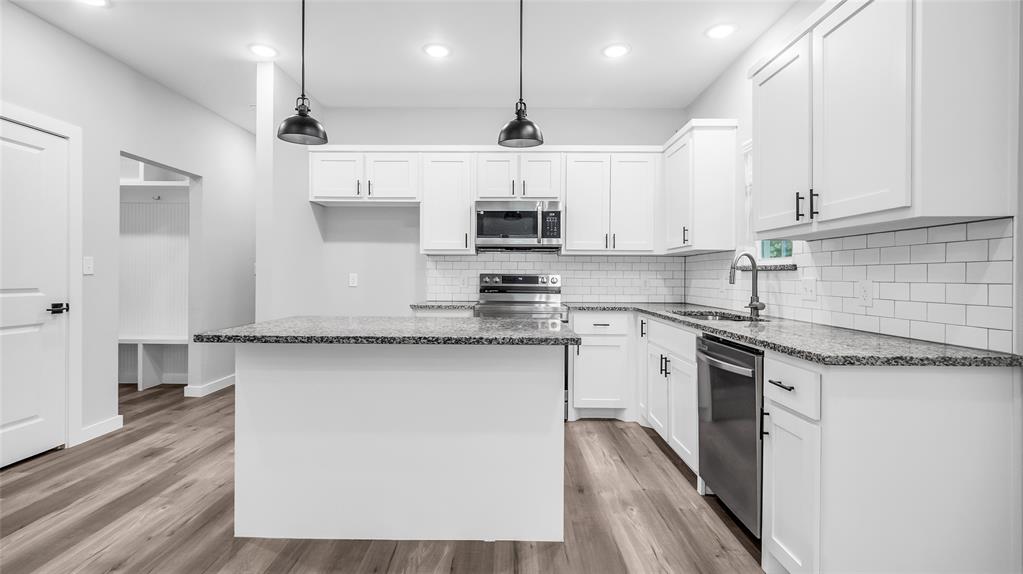 716 East Chestnut Street Denison, TX 75021 - Photo 12 of 26 Modern kitchen featuring white shaker cabinetry, stainless steel appliances, speckled stone countertops, and a white subway tile backsplash