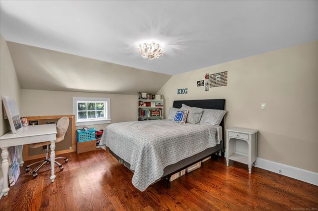 a bedroom with a bed and a wooden floor