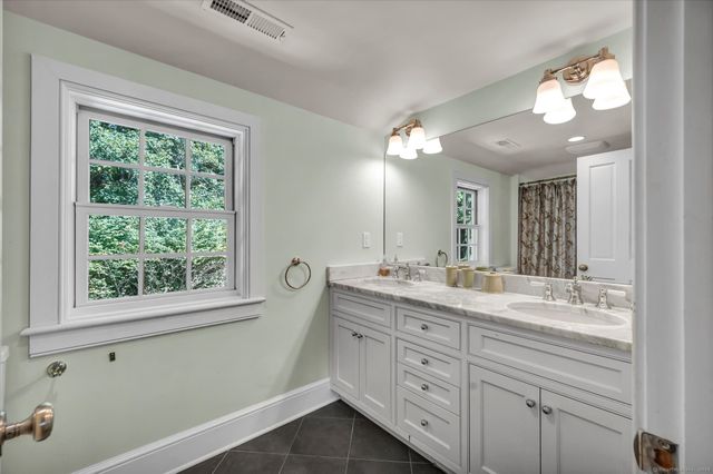 a bathroom with a double vanity sink and a mirror