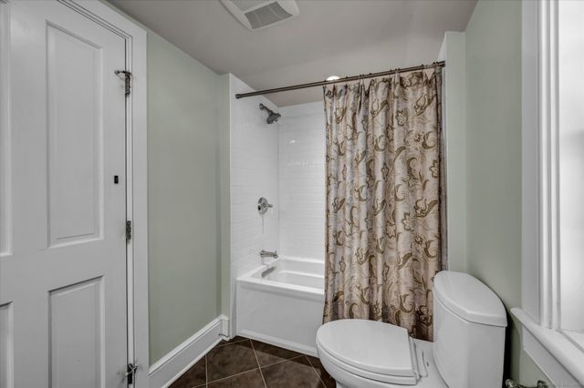 a white toilet and shower curtain