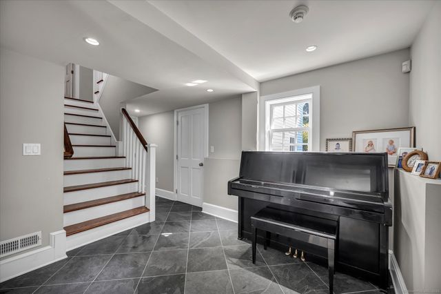 a living room with a piano and wooden floor
