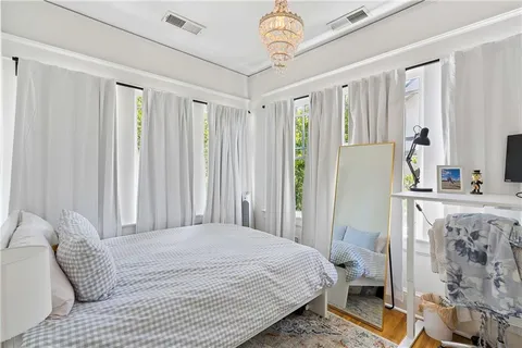 a bedroom with two beds and wooden floor