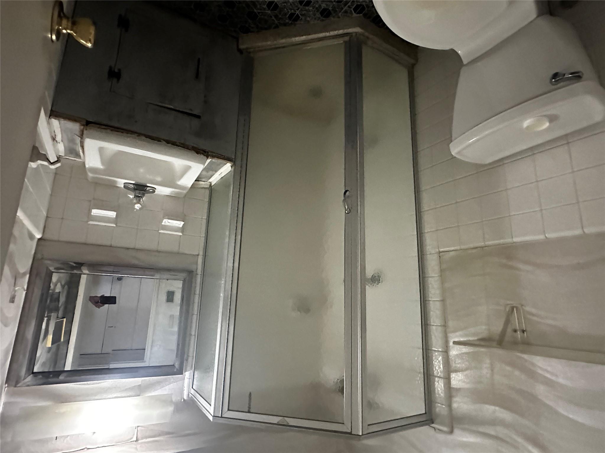 18-75 Corporal Kennedy Street, Unit 4A Queens, NY 11360 - Photo 16 of 25 Full bathroom featuring tile walls, vanity, a stall shower, and backsplash