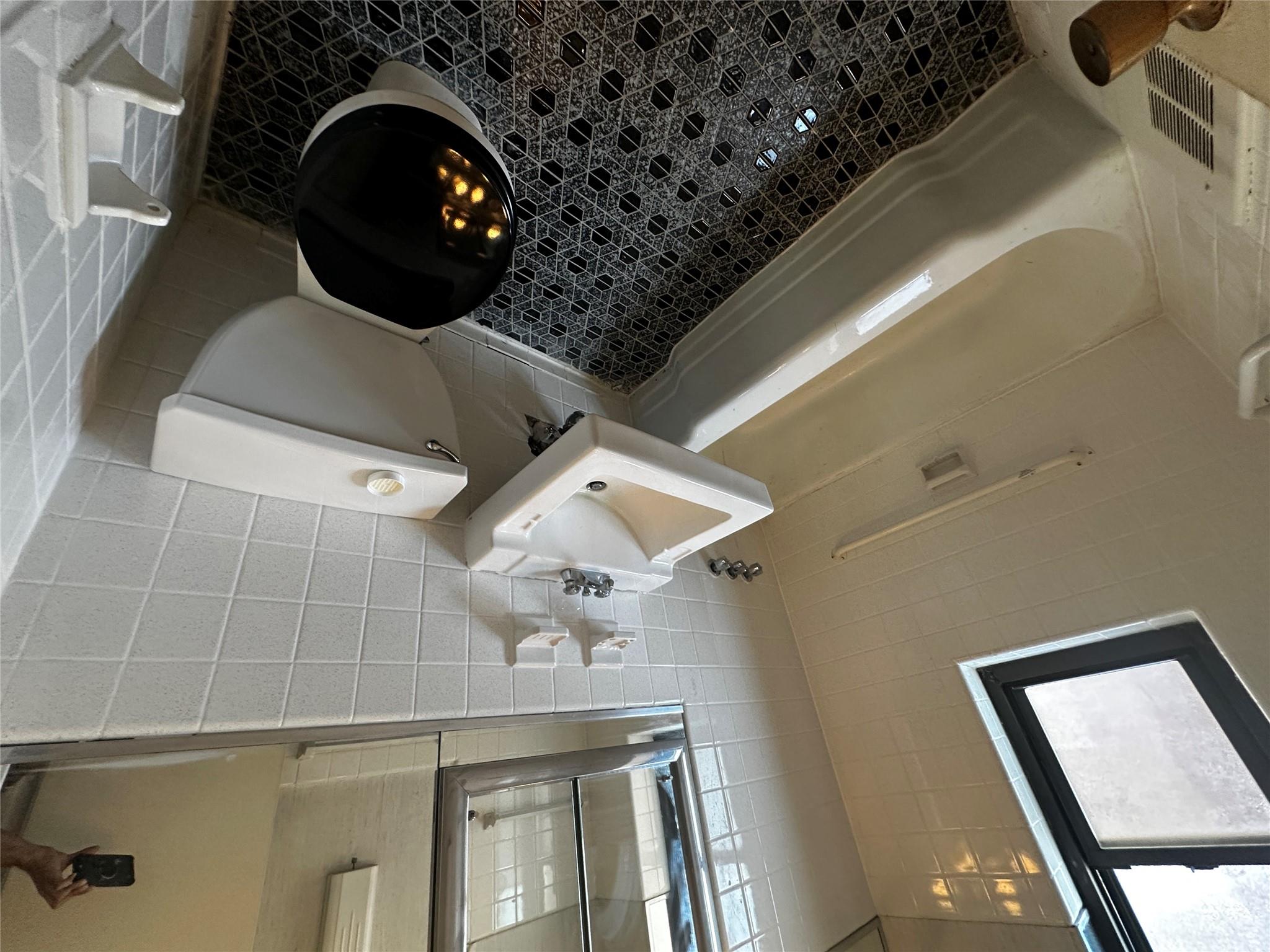 18-75 Corporal Kennedy Street, Unit 4A Queens, NY 11360 - Photo 18 of 25 Bathroom with tile walls, bathtub / shower combination, and tile patterned flooring