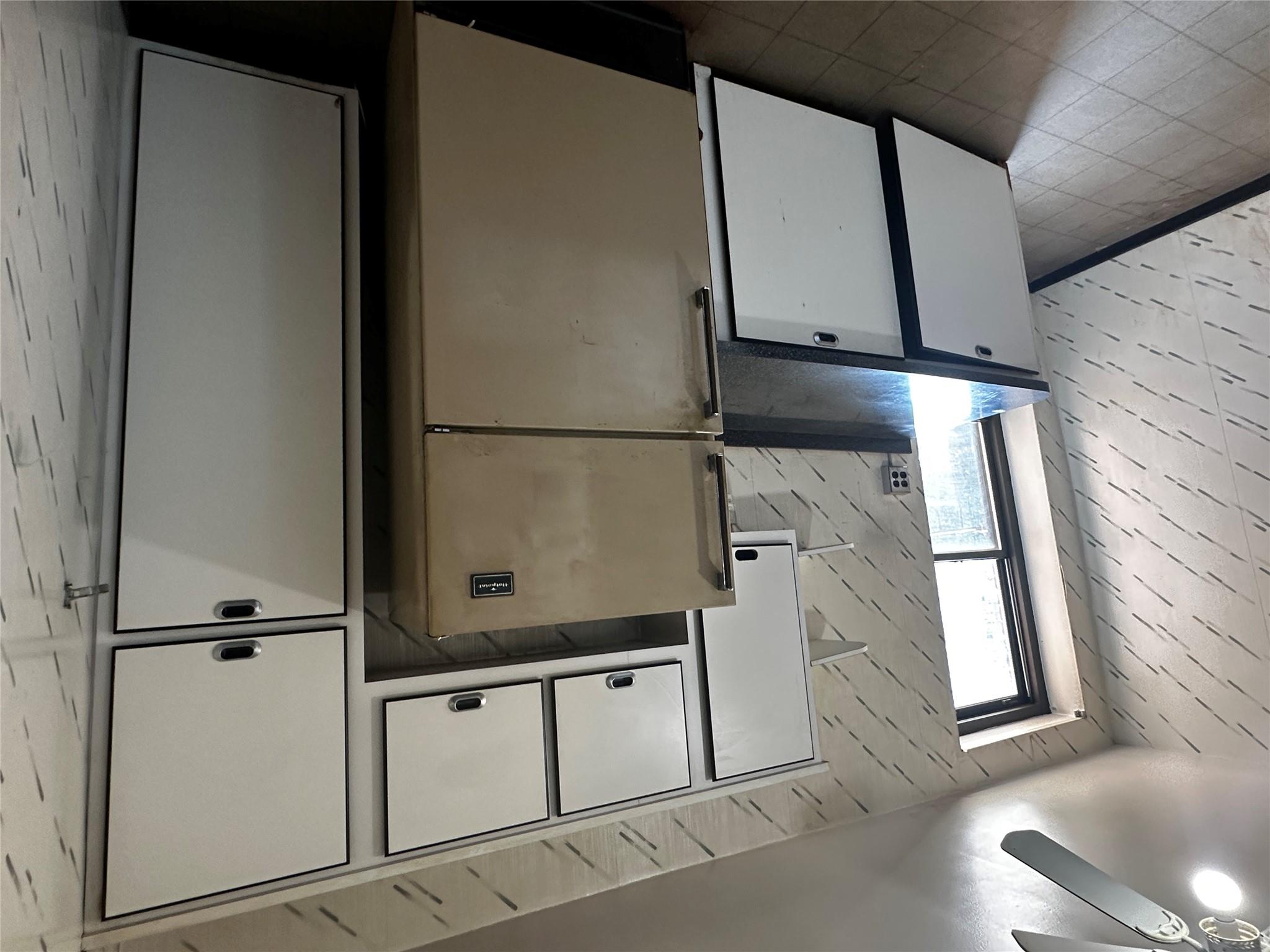 18-75 Corporal Kennedy Street, Unit 4A Queens, NY 11360 - Photo 8 of 25 Kitchen with fridge, a ceiling fan, white cabinetry, and dark countertops