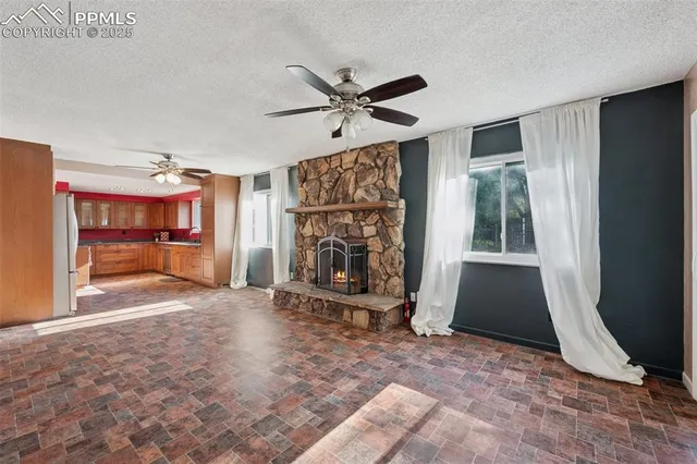 a view of an empty room with window and fire place