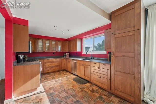 a kitchen with stainless steel appliances granite countertop a stove a sink and a microwave