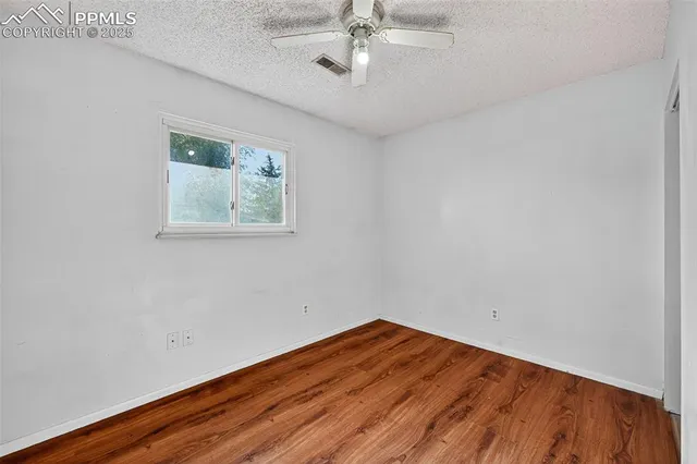 a view of an empty room with wooden floor