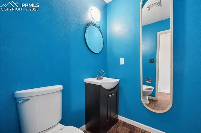 a view of an empty room with a window and kitchen view