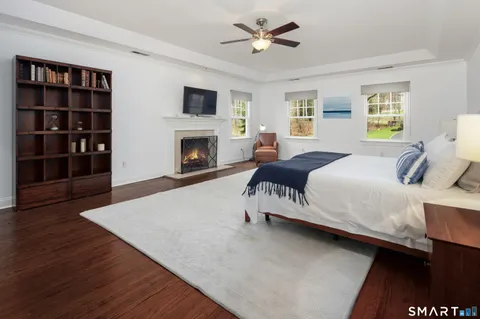 a spacious bedroom with a bed a couch and a chandelier