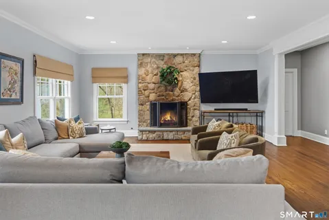 a living room with furniture a flat screen tv and a fireplace