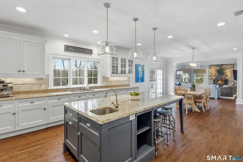 a view of a dining room and livingroom with furniture wooden floor a chandelier